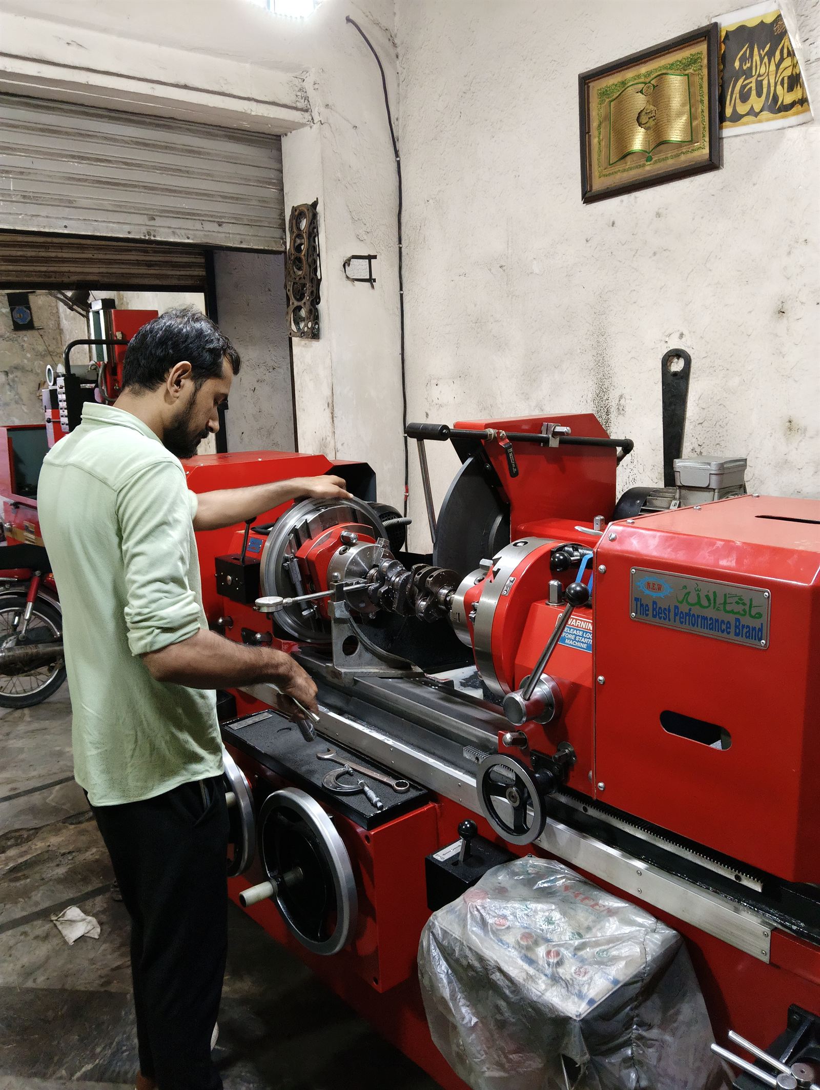 Crankshaft being set up on a precision grinder with a dial indicator at the workshop